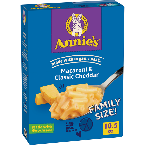 Box of Annie's Macaroni & Classic Cheddar pasta with a spoonful of macaroni on a blue background